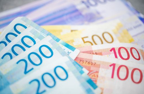 Norwegian Economy Theme. Colorful Norwegian Krones Banknotes on a Table. Cash Money.
